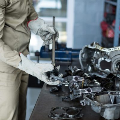 Mechanic checking a car parts Mechanic checking a car parts in repair shop